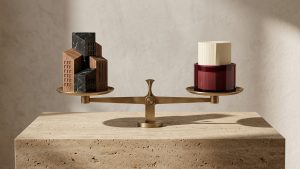 Composición escultórica en travertino, mármol negro, latón cepillado y cristal burdeos sobre la decisión entre amortizar hipoteca o invertir en renta fija