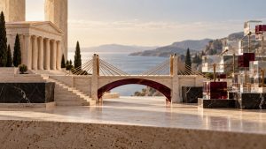 Templo neoclásico en piedra travertino unido mediante un puente de latón y cristal burdeos a una estructura geométrica de cubos de cristal